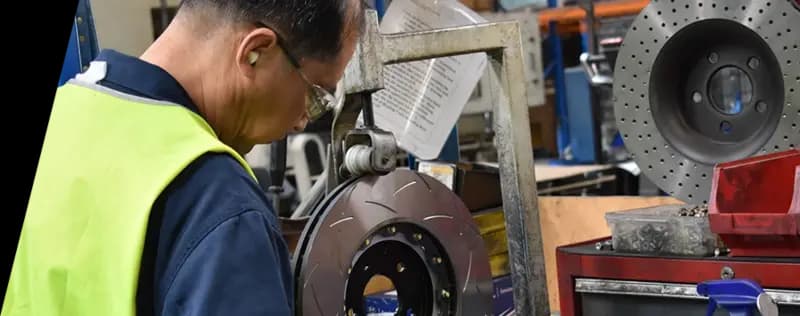 DBA Fabrikstechniker in Sicherheitsausrüstung bei der Arbeit an der Bremsscheibenproduktion mit spezieller Ausrüstung