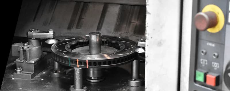 DBA Bremsscheibe mit farbigen Temperaturindikatoren in der Herstellung auf Präzisions-CNC-Maschine mit sichtbarem Bedienfeld