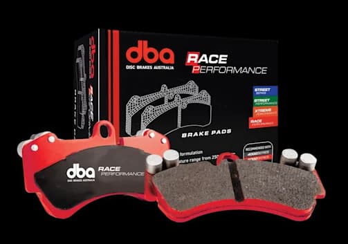 DBA Race Performance Bremsbeläge mit roten Trägerplatten und speziellem Reibmaterial neben der Verkaufsverpackung