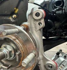 Schritt 4B: Identifizierung von Kontaktpunkten am Original-Radnabengehäuse, die für korrekte DBA-Bremssattelpassung entfernt werden müssen Original-Radnabengehäuse mit sichtbarem markiertem Kontaktbereich zur Modifikation für korrekten Freiraum bei DBA-Bremssattelinstallation