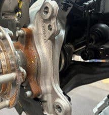 Schritt 4A: Überprüfung des Original-Radnabengehäuses auf potenzielle Kontaktpunkte mit DBA-Bremssattel nach Ankerplattenmodifikation Nahaufnahme des Original-Radnabengehäuses und modifizierter Ankerplatte mit potenziellen Kontaktpunkten zum DBA-Bremssattel